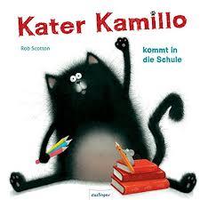 Eine Katze sitzt mit großen Augen vor Stiften und Büchern