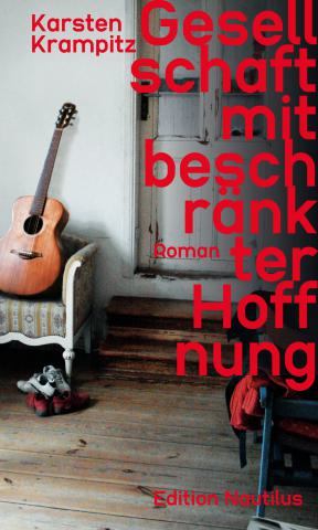 Ein Raumausschnitt mit Blick zur Tür, neben der eine Gitarre auf einem Sessel an der Wand lehnt.